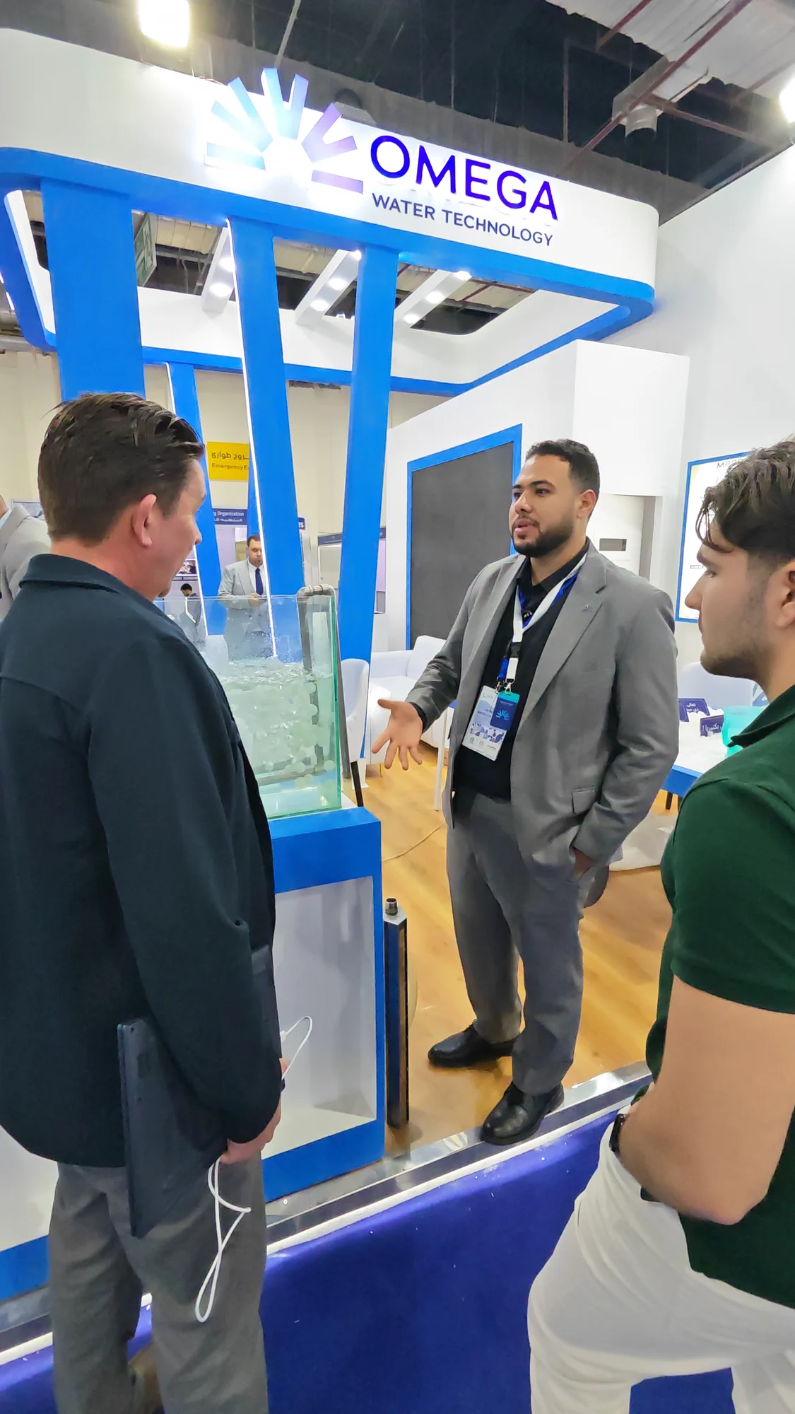 أحمد هلال يناقش تطبيقات المنتج مع زوار دوليين بجوار نموذج أوميجا